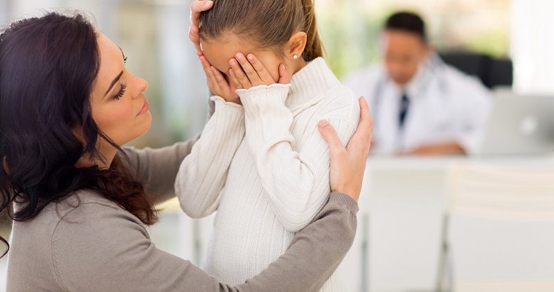 Public Violence: How a Pediatrician Can Help loving mother comforting her sick daughter in doctor's office