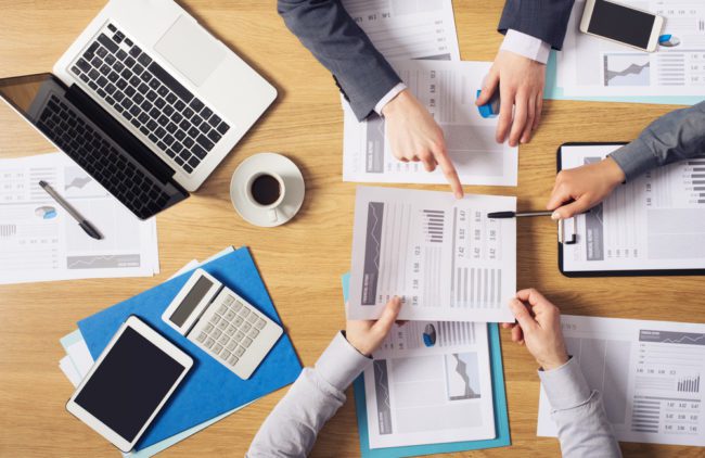 12 Reasons To Choose A Pediatric-Specific EHR Business people around a table with computers and financial reports