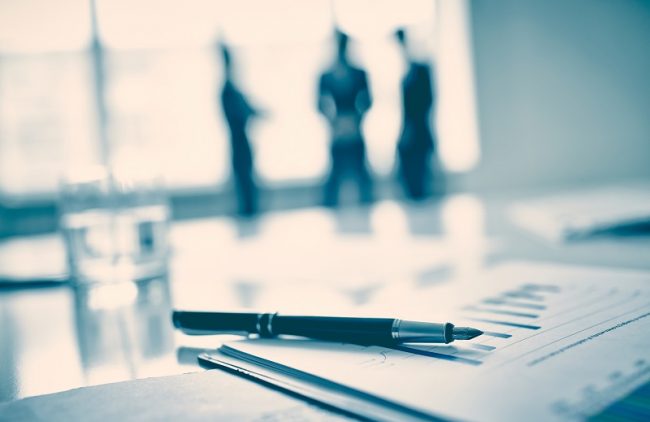 8 Tools to Help a Pediatric Practice Become a Successful Business Fountain pen on business document, three men standing on background