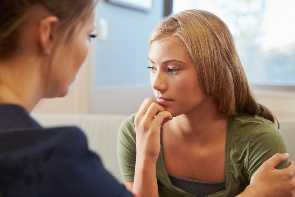 A nurse speaks with a depressed teen